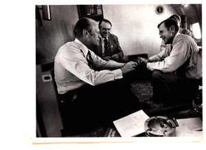 ["The image depicts Dewey Bartlett seated in an airplane with Gerald Ford, Henry Bellmon and another man"]