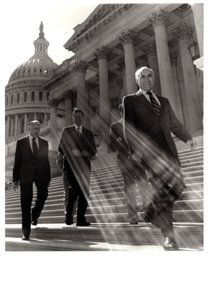 ["The image depicts Dewey Bartlett walking down the Capitol steps with Clifford Hansen and Paul Fanin, and two other men"]