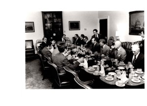 ["The image depicts Dewey Bartlett seated with several other men, including Jimmy Carter"]