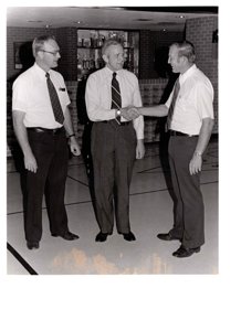 ["The image depicts Dewey Bartlett at the Medford Public School shaking hands with Ray Innis and Clen Campbell"]