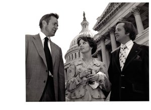 ["The image depicts Dewey Bartlett standing with Jill and Marty Adams in front of the capitol"]