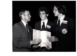 ["The image depicts Dewey Bartlett standing with Kevin Vaughn and Vernon Cowdry at the National Youth Science Camp"]