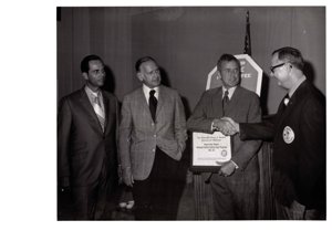 ["The image depicts Dewey Bartlett shaking hands with Jack Ward, who is representing the Oklahoma Restaurant Association and owner of Ward's Cafeteria"]