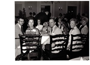 ["The image depicts Dewey Bartlett seated with Mrs. Smith and Mrs. Feizel (POW wives), and their families"]