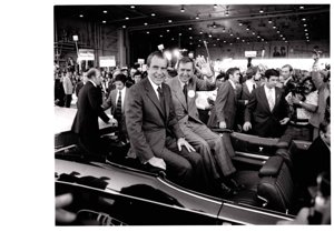 ["The image depicts Dewey Bartlett seated in the back of a car with Richard Nixon"]