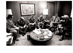 ["The image depicts Dewey Bartlett seated with (L to R) J. T. Milway, J. S. Heobert, D. E. Procknow, J. Prickett, and A. C. Foster"]