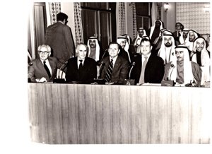 ["The image depicts Dewey Bartlett seated at the Federal National Assembly with Nather Omari, Clifford Hansen, Najmuddine Hamoodah, members of the Assembly with charge P. J. Griffen at the back and W. N. Howell, Jr. walking to the back"]