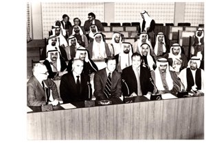 ["The image depicts Dewey Bartlett seated at the Federal National Assembly with Nather Omari, Clifford Hansen, Najmuddine Hamoodah, members of the Assembly with charge P. J. Griffen at the back and W. N. Howell, Jr. walking to the back"]