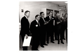 ["The image depicts Dewey Bartlett standing with several other men"]